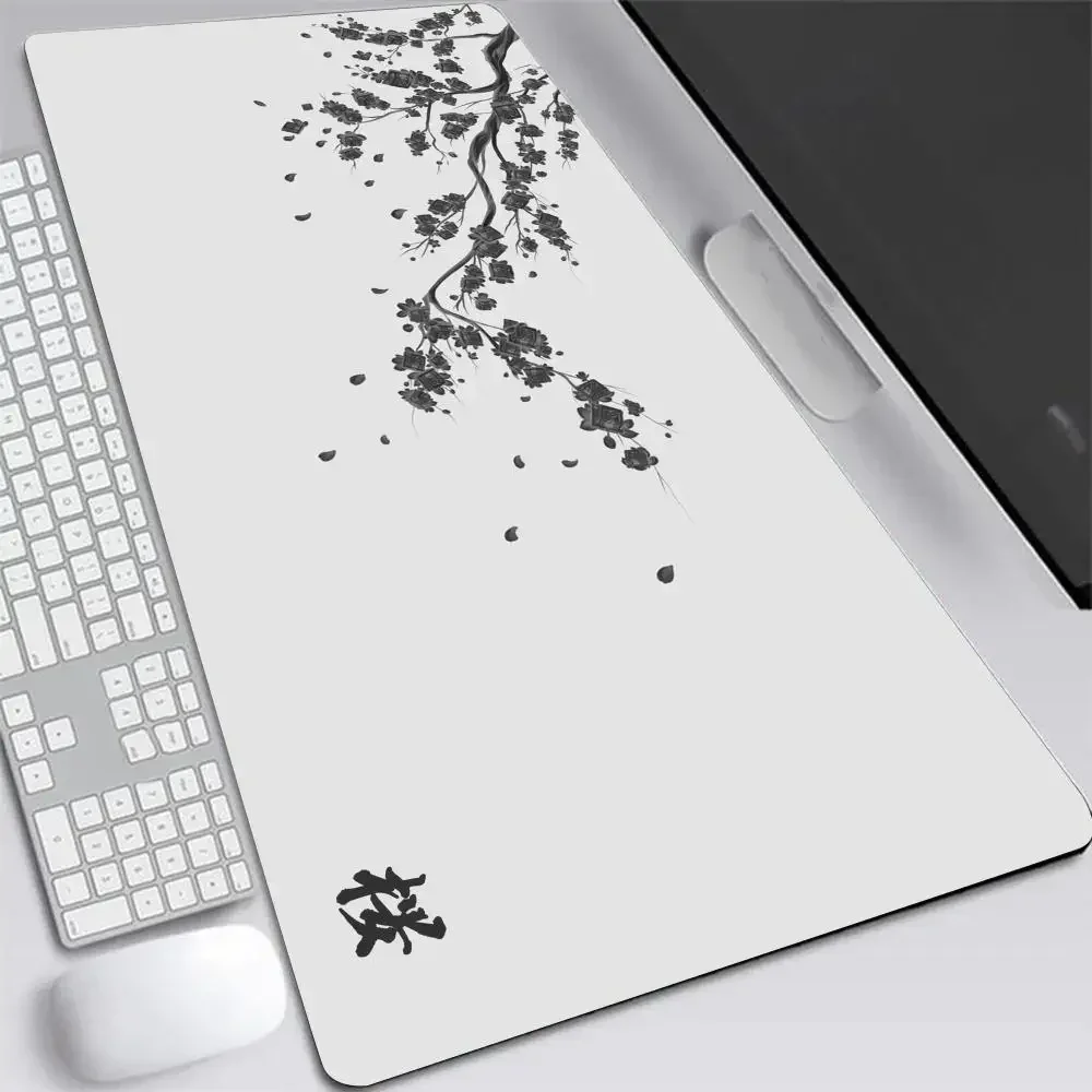 Tapis de souris blanc orné d'une branche de cerisier à l'encre et d'un idéogramme, posé à côté d'un clavier blanc